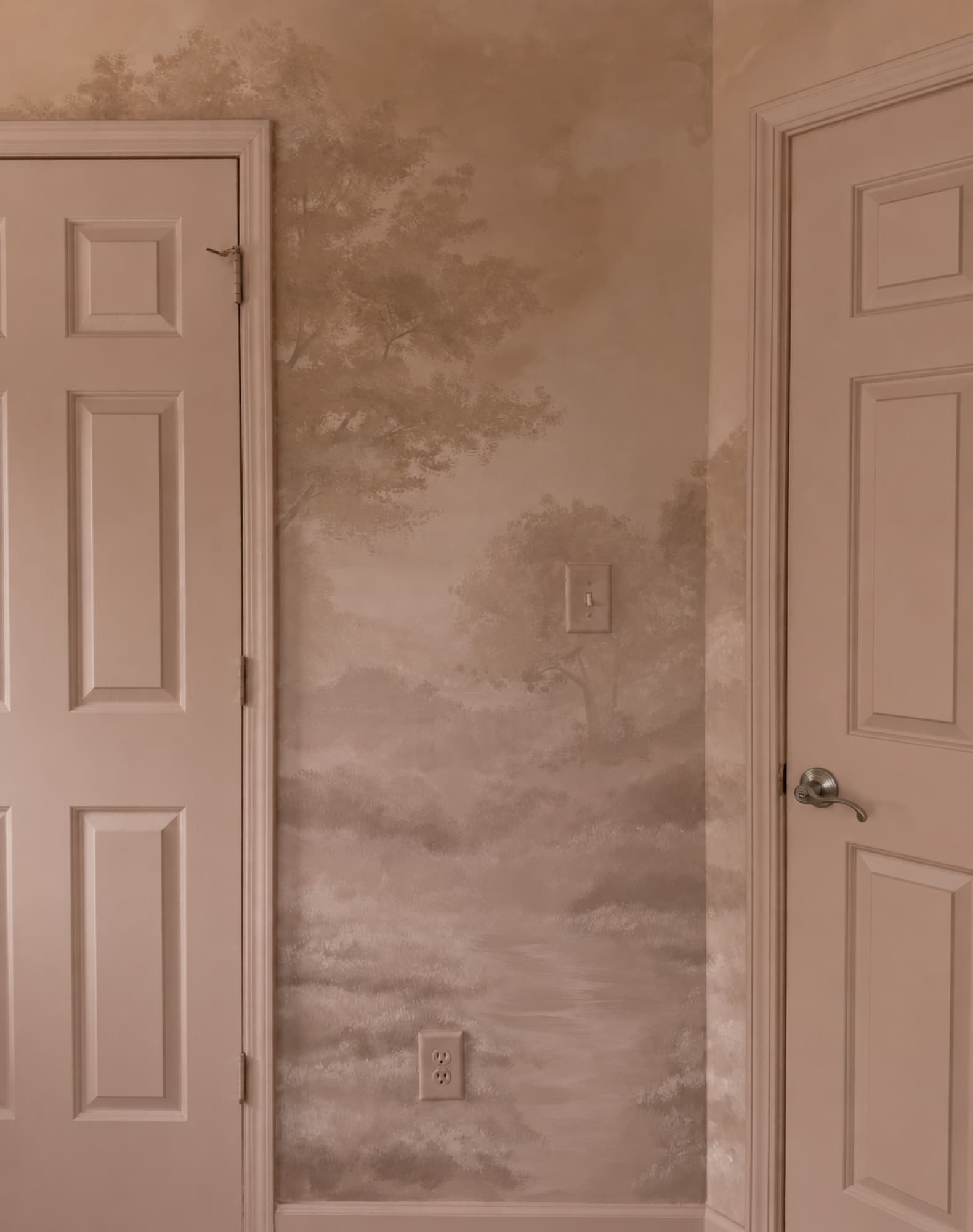 Sepia landscape mural with a doorway at left.